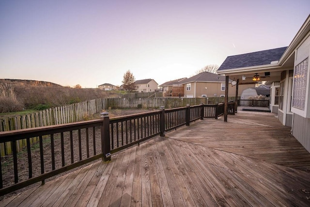 deck at dusk featuring ceiling fan