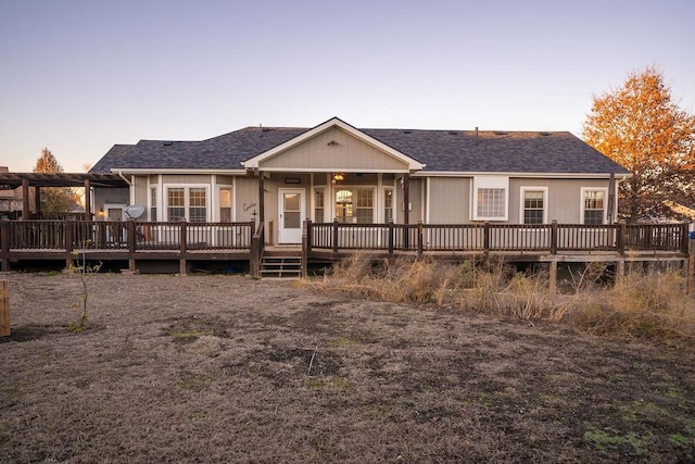 back house at dusk with a wooden deck