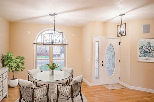 dining space featuring light hardwood / wood-style floors and a notable chandelier