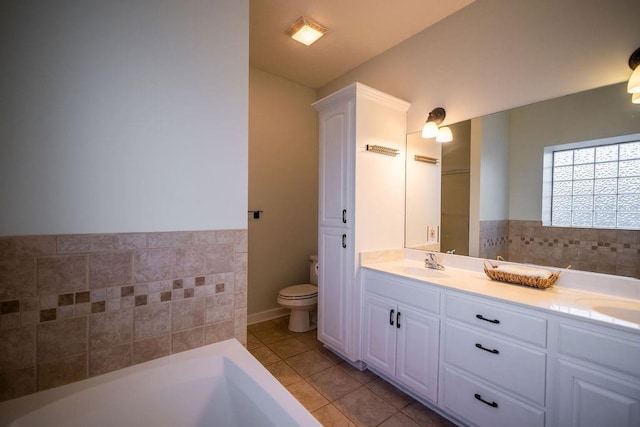 bathroom featuring toilet, a washtub, tile patterned flooring, and vanity