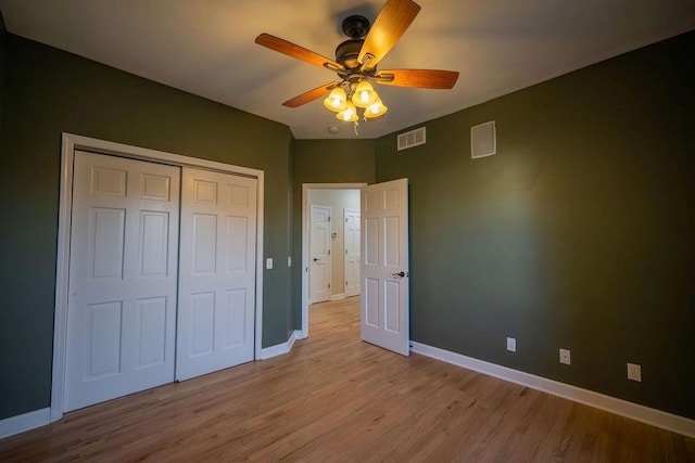 unfurnished bedroom featuring ceiling fan, light hardwood / wood-style flooring, and a closet