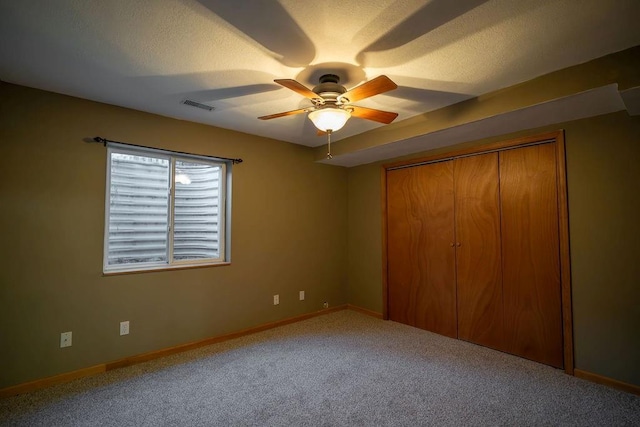 unfurnished bedroom featuring ceiling fan, a closet, and carpet floors