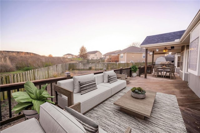 deck at dusk with ceiling fan and outdoor lounge area