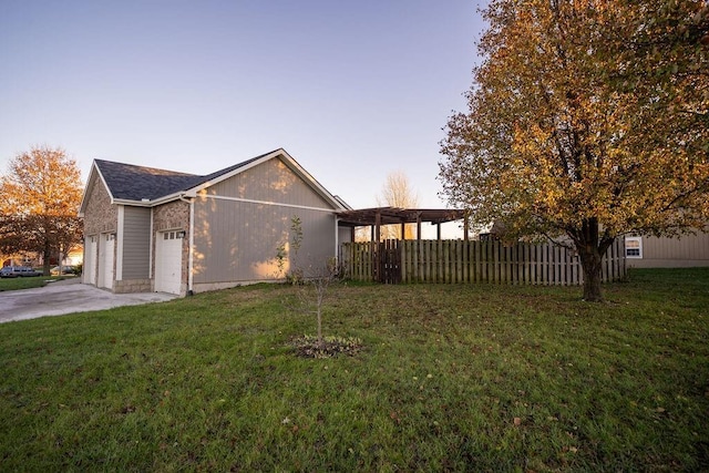 property exterior at dusk featuring a lawn and a garage