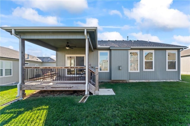 rear view of house featuring ceiling fan, a yard, and a wooden deck