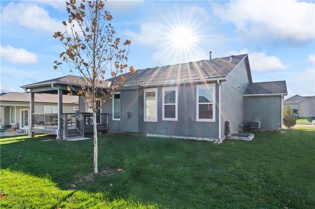 rear view of house with central AC, a yard, and a deck