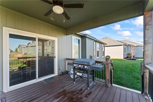 wooden terrace with a lawn, a grill, and ceiling fan