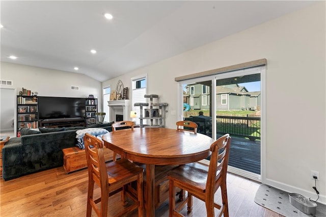 dining space featuring light hardwood / wood-style floors and lofted ceiling