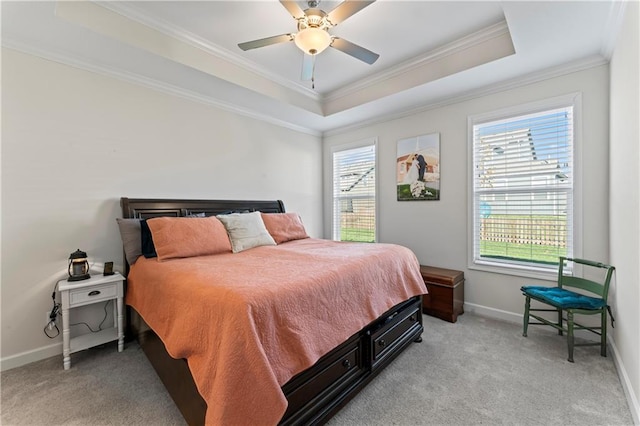 bedroom with ceiling fan, crown molding, light carpet, and a tray ceiling