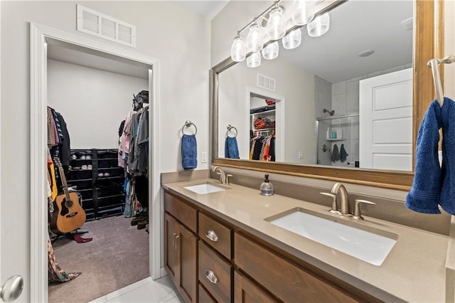 bathroom featuring tile patterned floors, vanity, and a shower with shower door