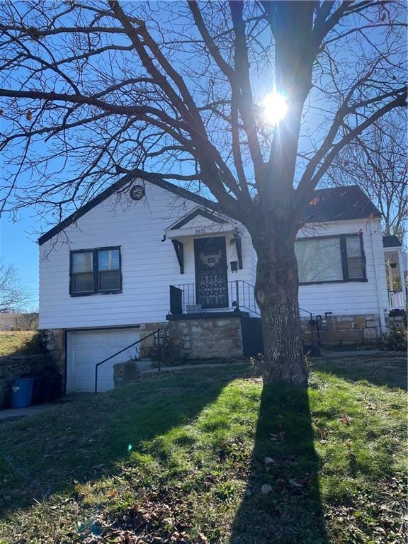 view of front of property with a front yard and a garage