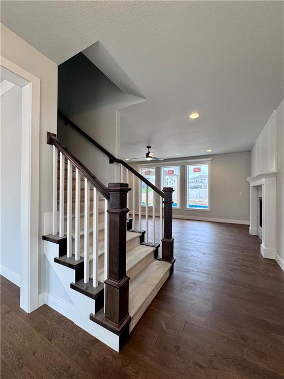 7601 NE 103rd Ter, Kansas City, MO 64157 - stairs featuring baseboards, wood finished floors, recessed lighting, and a fireplace