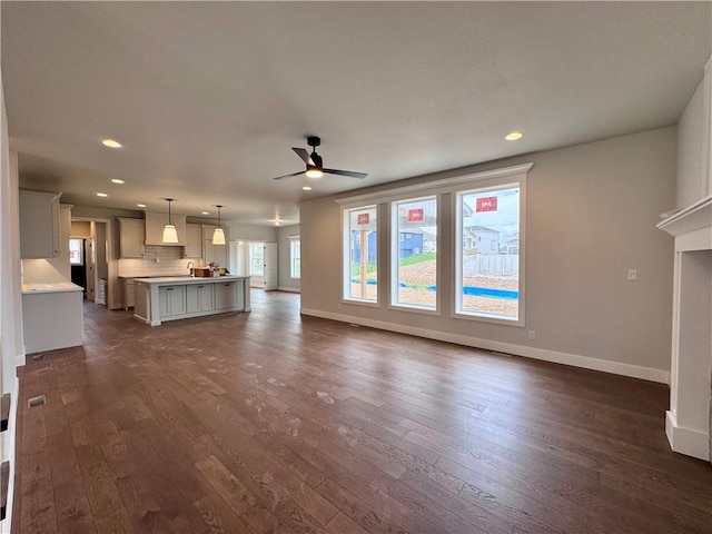 7601 NE 103rd Ter, Kansas City, MO 64157 - unfurnished living room with dark wood-type flooring, a ceiling fan, baseboards, and recessed lighting
