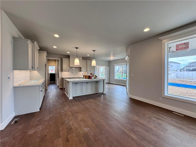 7601 NE 103rd Ter, Kansas City, MO 64157 - kitchen with light countertops, baseboards, backsplash, dark wood finished floors, and recessed lighting