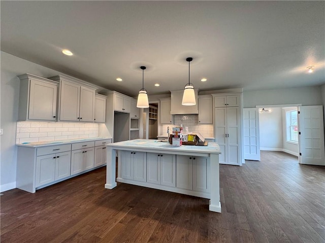 7601 NE 103rd Ter, Kansas City, MO 64157 - kitchen featuring baseboards, decorative backsplash, a center island with sink, dark wood-style floors, and recessed lighting