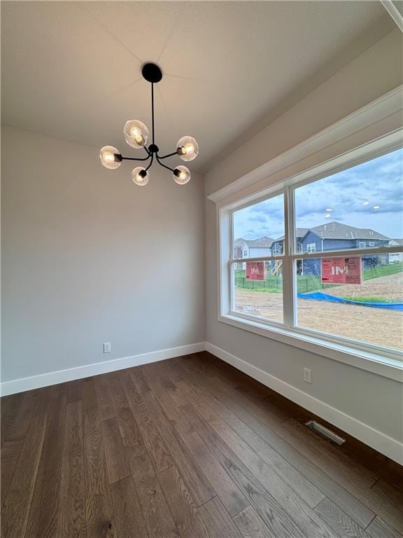 7601 NE 103rd Ter, Kansas City, MO 64157 - unfurnished dining area featuring a chandelier, dark wood-type flooring, and baseboards