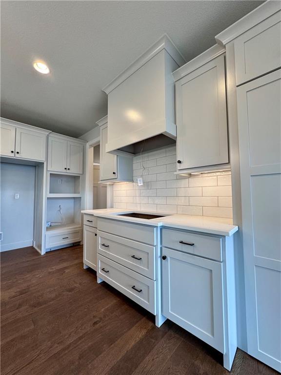 7601 NE 103rd Ter, Kansas City, MO 64157 - kitchen with black electric cooktop, decorative backsplash, dark wood-style floors, recessed lighting, and white cabinets