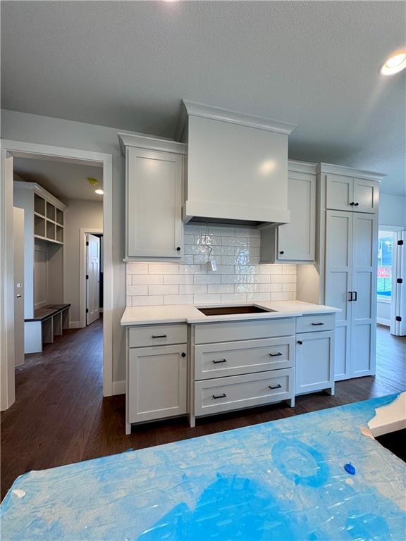 7601 NE 103rd Ter, Kansas City, MO 64157 - kitchen featuring light countertops, baseboards, tasteful backsplash, and dark wood-style floors