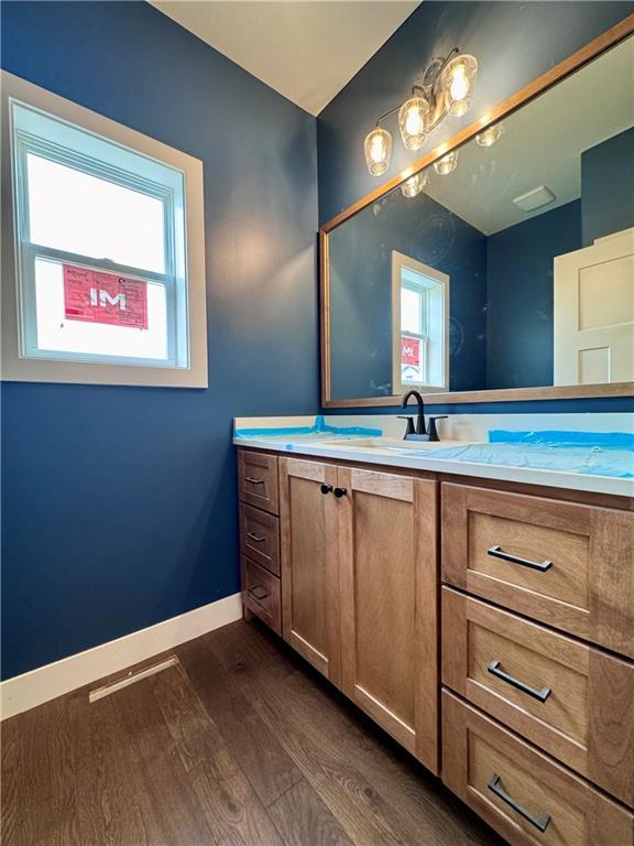 7601 NE 103rd Ter, Kansas City, MO 64157 - bathroom with wood finished floors, vanity, and baseboards