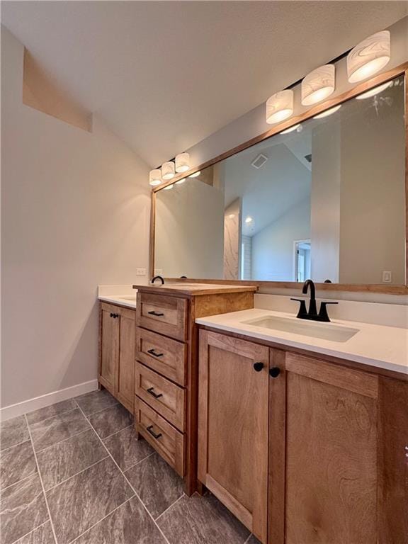 7601 NE 103rd Ter, Kansas City, MO 64157 - bathroom featuring vaulted ceiling, two vanities, and baseboards
