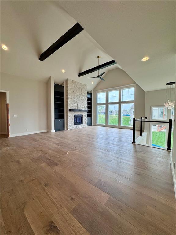7719 NE 103rd Ter, Kansas City, MO 64157 - unfurnished living room featuring a ceiling fan, hardwood / wood-style floors, a fireplace, baseboards, and recessed lighting