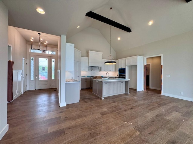 7719 NE 103rd Ter, Kansas City, MO 64157 - kitchen featuring a chandelier, high vaulted ceiling, a kitchen island with sink, wood finished floors, and recessed lighting