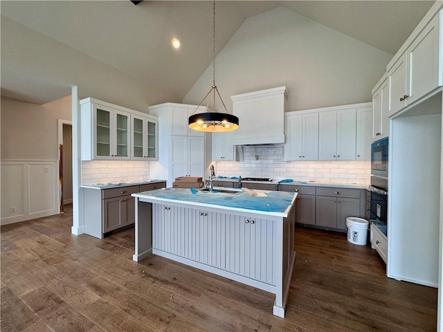 7719 NE 103rd Ter, Kansas City, MO 64157 - kitchen with a sink, black appliances, an island with sink, tasteful backsplash, and high vaulted ceiling