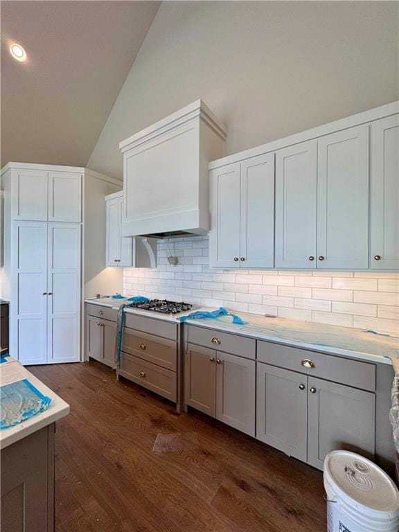 7719 NE 103rd Ter, Kansas City, MO 64157 - kitchen with lofted ceiling, dark wood-type flooring, backsplash, light countertops, and gas cooktop