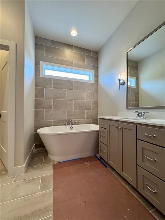 7719 NE 103rd Ter, Kansas City, MO 64157 - bathroom with vanity, tile patterned flooring, and a freestanding tub