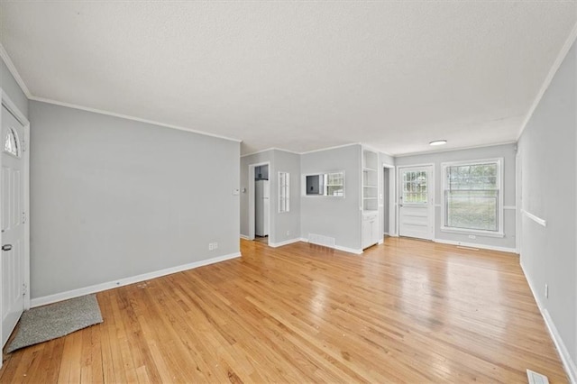 unfurnished living room featuring ornamental molding and light wood-type flooring