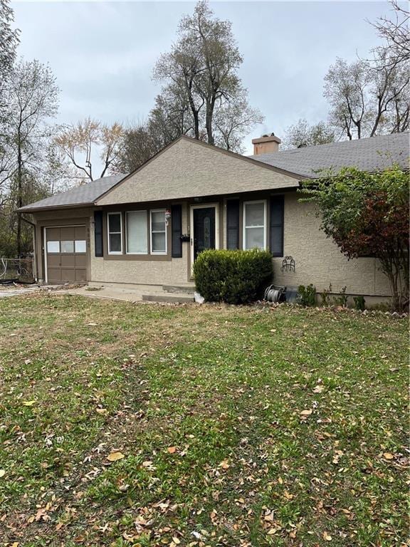 view of front of home with a front yard and a garage