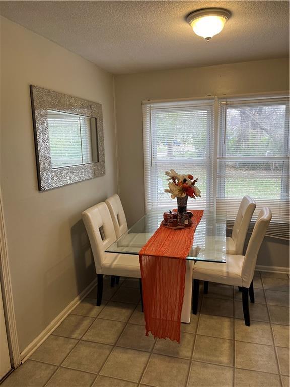 dining area with tile patterned flooring and a textured ceiling