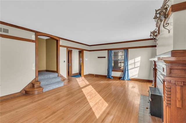 unfurnished living room featuring crown molding and hardwood / wood-style flooring