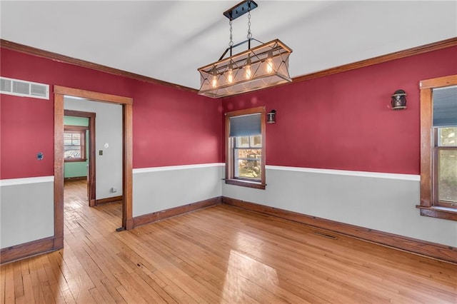 empty room featuring hardwood / wood-style flooring and crown molding