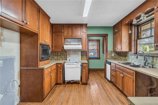 kitchen featuring tasteful backsplash, sink, white appliances, and light wood-type flooring