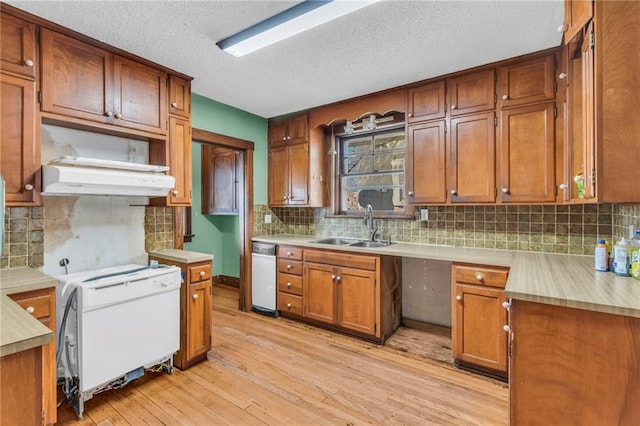 kitchen featuring a textured ceiling, decorative backsplash, light hardwood / wood-style floors, and sink