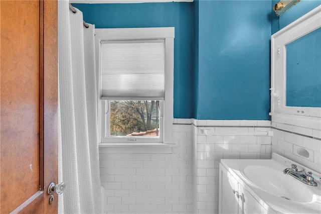 bathroom featuring vanity and tile walls