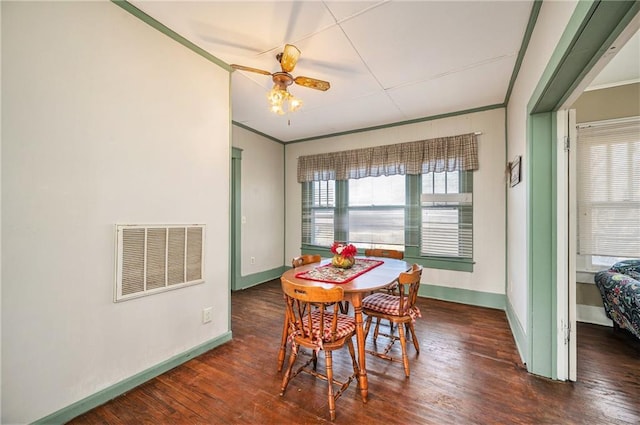 dining space with dark hardwood / wood-style floors, ceiling fan, and ornamental molding