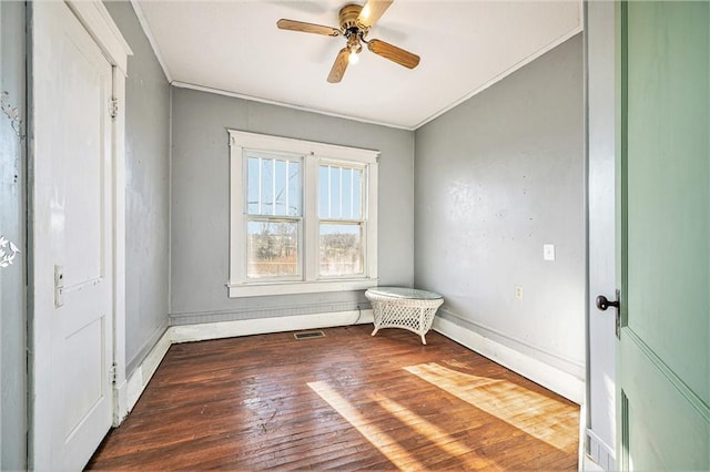 spare room featuring ceiling fan, dark hardwood / wood-style flooring, and crown molding