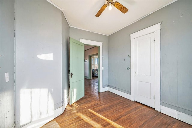 interior space featuring ceiling fan, crown molding, and dark hardwood / wood-style floors