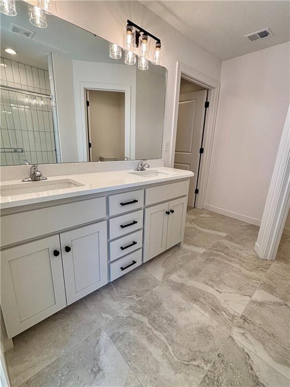 bathroom with marble finish floor, visible vents, a sink, and double vanity