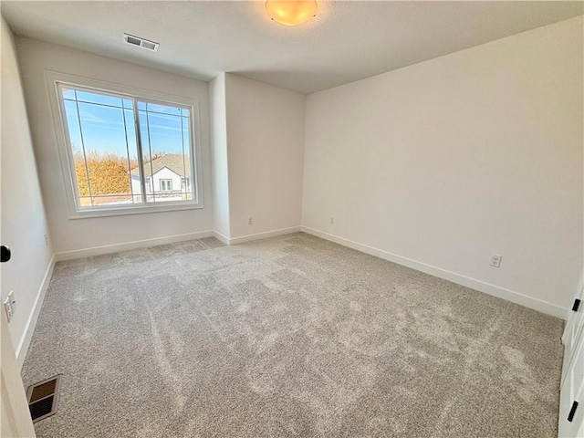 unfurnished room featuring baseboards, visible vents, and light colored carpet