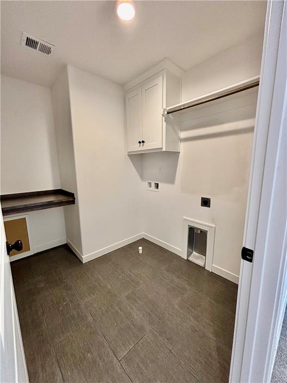 laundry room with cabinet space, baseboards, visible vents, dark wood finished floors, and hookup for a washing machine