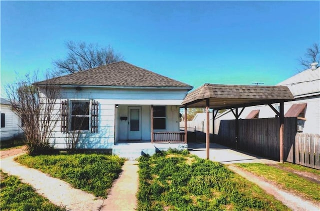 back of house featuring a porch and a carport