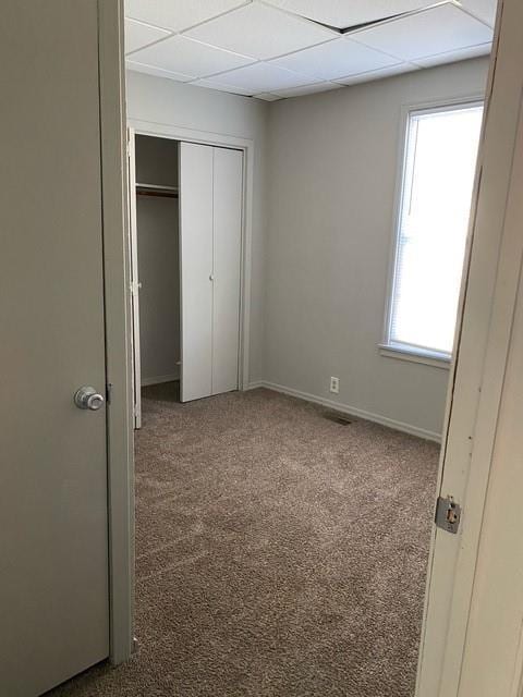 unfurnished bedroom with dark carpet and a closet