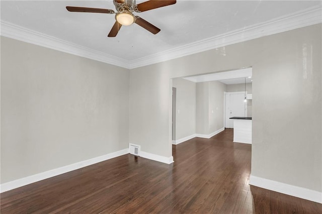 empty room featuring ceiling fan, crown molding, and dark wood-type flooring