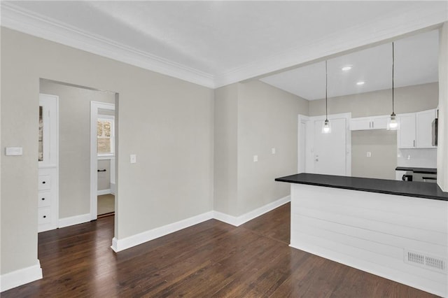 kitchen with white cabinetry, hanging light fixtures, dark hardwood / wood-style floors, and ornamental molding