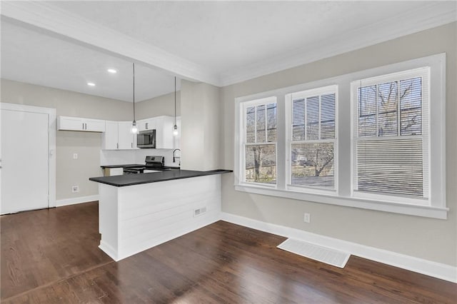 kitchen with kitchen peninsula, appliances with stainless steel finishes, dark wood-type flooring, decorative light fixtures, and white cabinetry