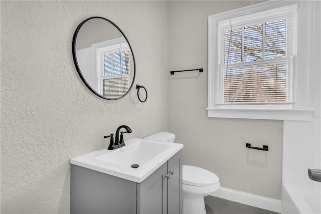 bathroom featuring plenty of natural light, vanity, and toilet