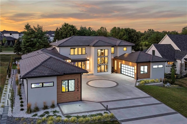 12604 W 160th St, Overland Park, KS 66062 - contemporary home featuring curved driveway, a garage, stucco siding, and a tiled roof